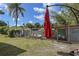 Backyard with a chicken coop and outdoor patio umbrella, creating a serene and functional space at 5572 Myakka Ave, Intercession City, FL 33848