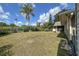 Expansive backyard featuring lush grass, mature trees, and partial view of the home's exterior at 5572 Myakka Ave, Intercession City, FL 33848