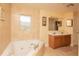 Bathroom highlighting a jetted tub, double sinks, and neutral tile work at 5572 Myakka Ave, Intercession City, FL 33848