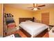 Bedroom with wood floors features a ceiling fan and a bed with storage underneath. There are suitcases stacked near the door at 5572 Myakka Ave, Intercession City, FL 33848