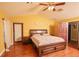 Bright bedroom featuring a ceiling fan, hardwood floors, and a comfortable bed at 5572 Myakka Ave, Intercession City, FL 33848