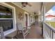 Inviting covered front porch with rocking chairs, nautical decor, and classic white columns at 5572 Myakka Ave, Intercession City, FL 33848