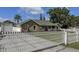 Single-story home with well-manicured lawn, garage, and ample parking behind a decorative fence at 5572 Myakka Ave, Intercession City, FL 33848