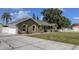 Single-story home with well-manicured lawn, garage, and ample parking on driveway at 5572 Myakka Ave, Intercession City, FL 33848