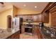 Kitchen with granite counters features stainless steel appliances, wood cabinets, and a breakfast bar at 5572 Myakka Ave, Intercession City, FL 33848