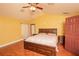 Vaulted ceiling main bedroom with laminate flooring, ensuite bathroom, and a ceiling fan at 5572 Myakka Ave, Intercession City, FL 33848