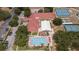 Aerial view of community center with swimming pool, tennis courts, shuffleboard, event tent, and ample parking at 5919 Mcenroe Ct, Leesburg, FL 34748