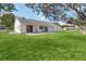 Lush green backyard featuring a well-manicured lawn, mature trees, and a patio area for outdoor enjoyment at 5919 Mcenroe Ct, Leesburg, FL 34748
