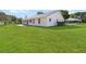 Spacious backyard featuring a lush green lawn and mature landscaping around the home's perimeter at 5919 Mcenroe Ct, Leesburg, FL 34748