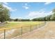 Vast baseball field enclosed with a green chain link fence under a sunny sky with trees in background at 5919 Mcenroe Ct, Leesburg, FL 34748
