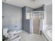 Spacious bathroom featuring a glass-enclosed shower, soaking tub, toilet, bidet and white tiled floors at 5919 Mcenroe Ct, Leesburg, FL 34748