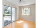Bright bedroom with natural light from the sliding glass door and window, and beautiful light-colored wood floors at 5919 Mcenroe Ct, Leesburg, FL 34748