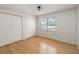 Bedroom with hardwood floors, closet doors, and a window at 5919 Mcenroe Ct, Leesburg, FL 34748