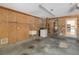 Utility garage with laundry, wash basin, pegboard walls, storage shelves, and door to the kitchen at 5919 Mcenroe Ct, Leesburg, FL 34748