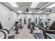 Gym featuring modern exercise equipment, mirrors, wood-look floors, and ceiling fans at 5919 Mcenroe Ct, Leesburg, FL 34748