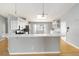 Kitchen with white cabinets, breakfast bar, stainless steel appliances and modern lighting at 5919 Mcenroe Ct, Leesburg, FL 34748