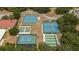 Aerial view of well-maintained tennis and sports courts surrounded by lush trees in a vibrant community at 5919 Mcenroe Ct, Leesburg, FL 34748