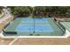 Up close view of two outdoor tennis courts with nets, benches, and shelter in a beautiful, fenced-in area at 5919 Mcenroe Ct, Leesburg, FL 34748