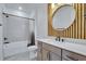 Stylish bathroom features a circular mirror, a modern vanity, gray subway tiles, and black hardware at 6494 Rover Way, St Cloud, FL 34771