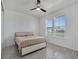 Well-lit bedroom features a modern bed frame, neutral-toned bedding, a ceiling fan, and wood-look tile floors at 6494 Rover Way, St Cloud, FL 34771