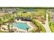 Community pool with lounge chairs, shady palm trees, picnic seating, and a playground on a sunny day at 6494 Rover Way, St Cloud, FL 34771