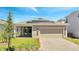 Charming one-story home featuring an attached two-car garage, brick paved driveway, and solar panels on the roof at 6494 Rover Way, St Cloud, FL 34771
