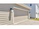 Exterior shot of a garage door with brick-paver driveway and modern outdoor lighting at 6494 Rover Way, St Cloud, FL 34771