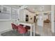 Bright kitchen with white cabinets, stainless appliances, long island, and three red velvet chairs at 6494 Rover Way, St Cloud, FL 34771