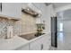 Close-up of a modern kitchen with a stylish backsplash, stainless steel appliances, and quartz countertops at 6494 Rover Way, St Cloud, FL 34771