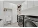 Well-organized laundry room with washer, dryer, sink, and built-in storage shelves and cabinets at 6494 Rover Way, St Cloud, FL 34771