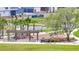 Community playground with a swing set, slide, picnic area, and benches surrounded by palm trees and green lawns at 6494 Rover Way, St Cloud, FL 34771