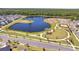 Aerial view of a pond surrounded by a park with walking paths and green space in a residential area at 6494 Rover Way, St Cloud, FL 34771