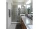 Bathroom with double sinks, gray counter tops, wooden cabinets, and a glass enclosed shower at 6617 Harper Way, Harmony, FL 34773