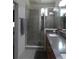 Modern bathroom with a glass-enclosed shower, double vanity, and neutral tile at 6617 Harper Way, Harmony, FL 34773