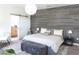 Comfortable bedroom with accent wall, barn door to bath, and ambient lighting at 6617 Harper Way, Harmony, FL 34773