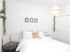 Bright bedroom with a white bed, neutral accents, and a woven pendant light at 6617 Harper Way, Harmony, FL 34773