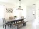 Bright dining room features long dining table and bench with decorative lighting and modern art at 6617 Harper Way, Harmony, FL 34773