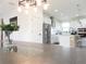 Dining room with modern chandelier and furniture opens to a bright kitchen with stainless steel appliances at 6617 Harper Way, Harmony, FL 34773