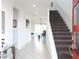 Bright entryway with tile flooring, a staircase, and access to the living and dining areas at 6617 Harper Way, Harmony, FL 34773