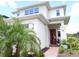 Bright home featuring a red front door, lush landscaping, and modern architectural details at 6617 Harper Way, Harmony, FL 34773