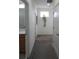 Well-lit hallway with neutral carpet and white walls, featuring a plant and access to multiple rooms at 6617 Harper Way, Harmony, FL 34773
