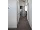 Bright hallway with neutral carpet and fresh paint, featuring access to multiple rooms and a clean, modern aesthetic at 6617 Harper Way, Harmony, FL 34773