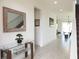 Long hallway with a decorative mirror and artwork, leading to the stairway and other areas of the home at 6617 Harper Way, Harmony, FL 34773