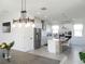 Stylish kitchen with a central island, white cabinets, stainless appliances, and modern lighting at 6617 Harper Way, Harmony, FL 34773