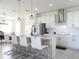Modern kitchen island with bar seating, stainless steel appliances, and stylish pendant lighting at 6617 Harper Way, Harmony, FL 34773