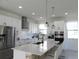 Well-lit kitchen featuring white cabinets, stainless steel appliances, and a large central island at 6617 Harper Way, Harmony, FL 34773