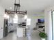 Open-concept kitchen with a large island, modern lighting, and a cozy living space at 6617 Harper Way, Harmony, FL 34773