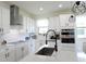 Bright and modern kitchen featuring white cabinetry, stainless appliances, and modern pendant lighting at 6617 Harper Way, Harmony, FL 34773