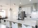 Bright eat-in kitchen featuring a large center island with white quartz countertops, stainless steel appliances, and modern lighting at 6617 Harper Way, Harmony, FL 34773