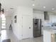 Bright kitchen with stainless steel appliances, white cabinetry, and a view of the entry at 6617 Harper Way, Harmony, FL 34773
